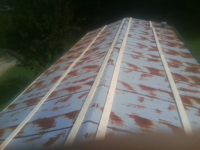Rusted metal roof panels with new wood purlins before replacement — Storm Damage Roof Repair in Cornwall by Roofing Brothers